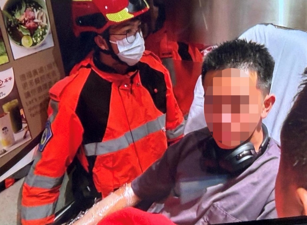 協助救火的職員手臂受傷，救護員用塑膠膜包裹其臂。讀者提供