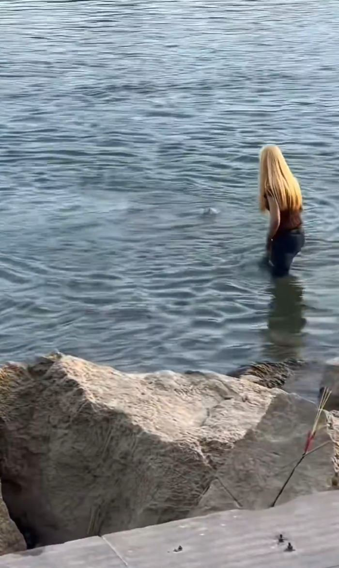 少女落水遇溺后，只有金发女试图营救，但另一男伴则只在岸边饮奶茶。