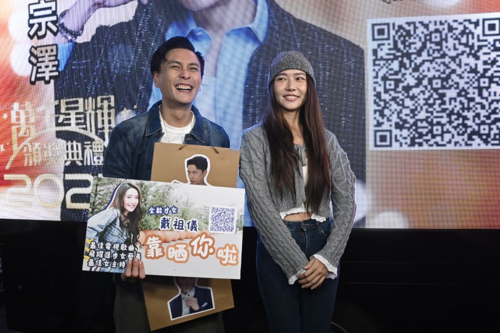 期间戴祖仪突然杀入，拿着自己的拉票宣传牌，与Bosco合照，互相为对方拉票。