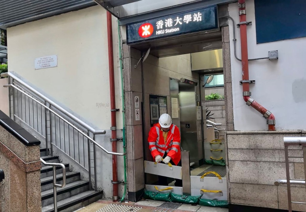 港鐵人員在有需要的車站出入口安裝防洪板以作預防。 港鐵人員在有需要的車站出入口安裝防洪板以作預防。
