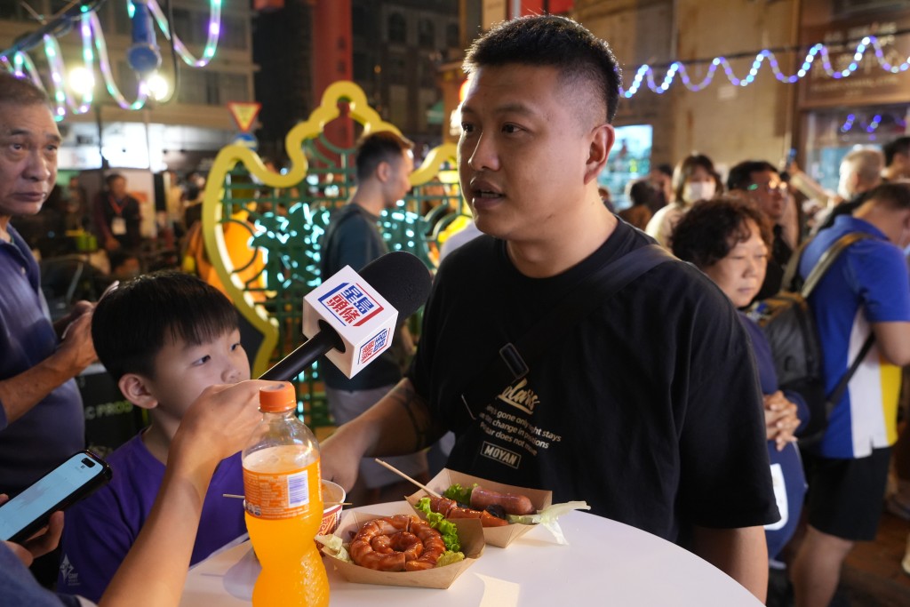 市民柳先生特意带儿子来庙街吃小食，认为价钱可以接受。刘骏轩摄