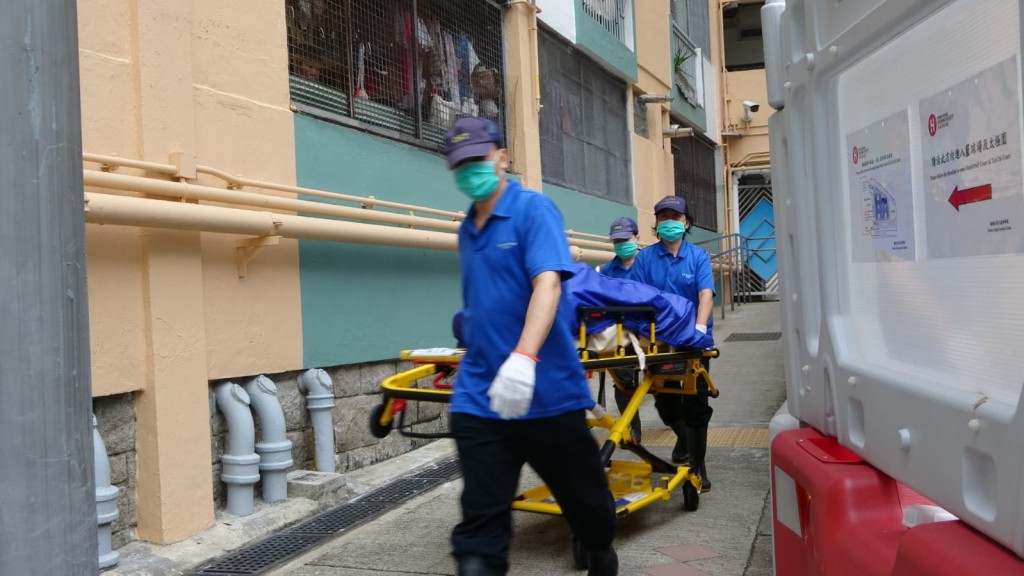 女死者屍體由仵工移離現場。