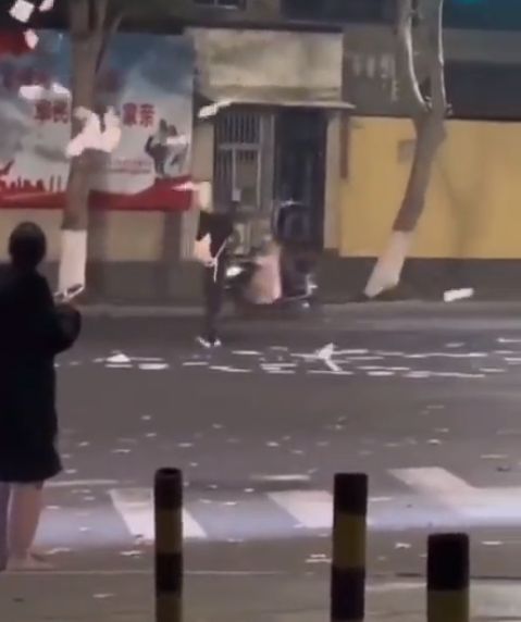 網上影片顯示一名男子在街上大撒白紙。