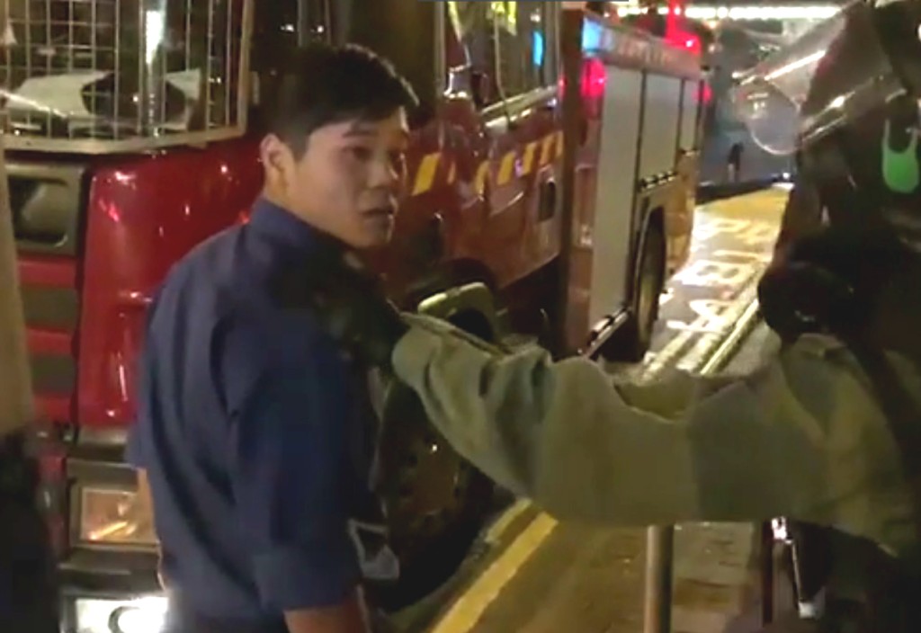 一名消防員向在場防暴警員投訴,雙方發生爭拗。台灣中視截圖