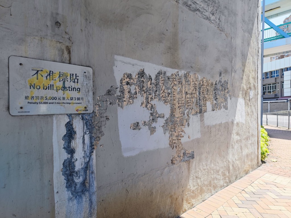 位於旺角界限街鐵路橋下一幅牆身，近日部分油漆剝落露出底層的曾灶財昔日真迹。資料圖片