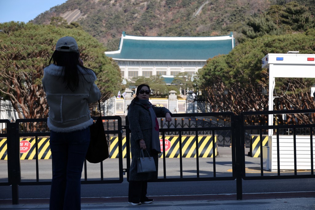 12月22日，遊客在韓國首爾的青瓦台門前拍照。 路透社