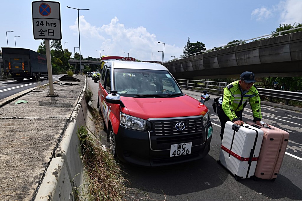 警員協助乘客搬行李往另一的士離去。梁國峰攝 警員協助乘客搬行李往另一的士離去。梁國峰攝