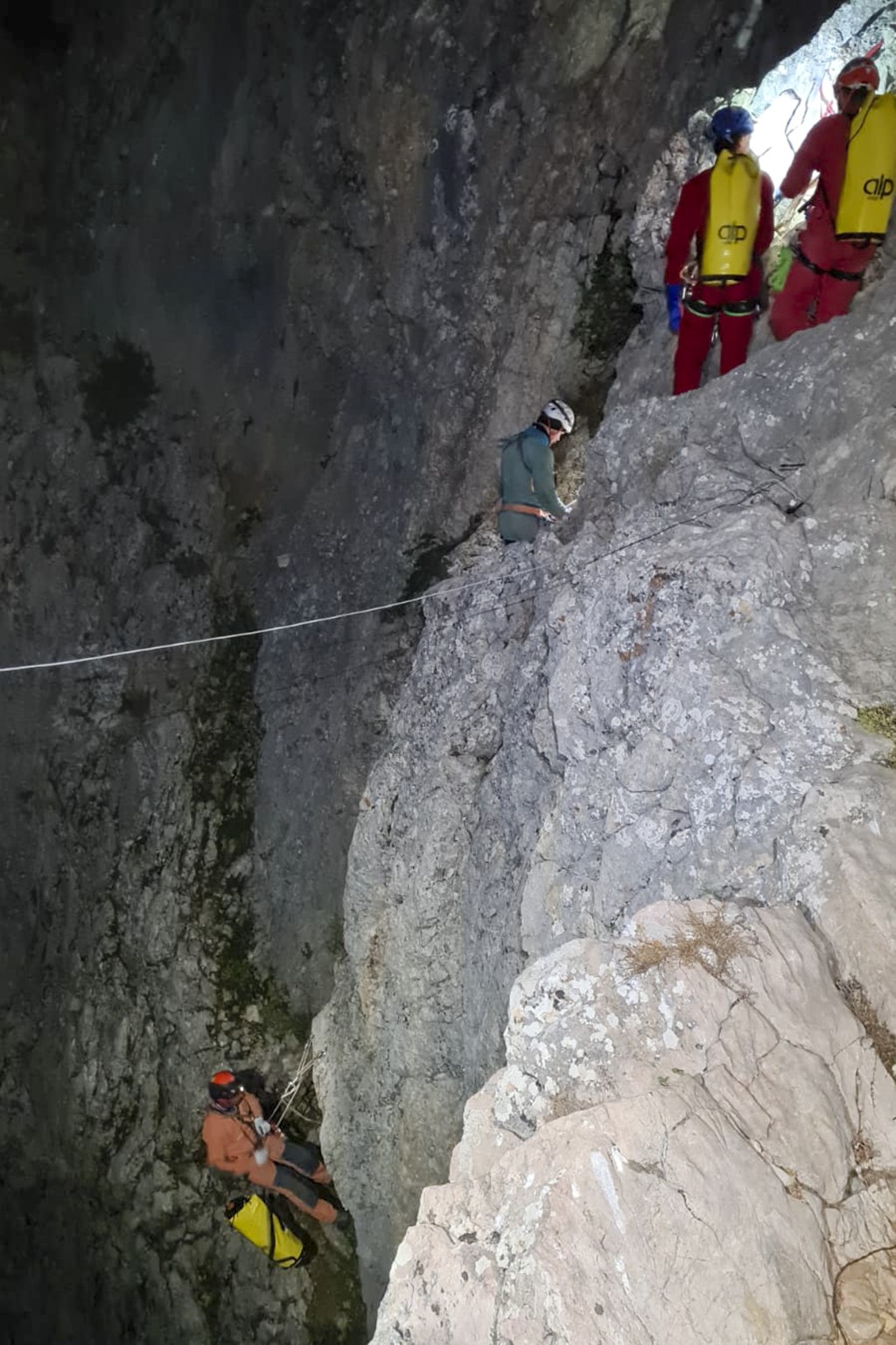救援隊以繩索沿著洞穴移動，穿過狹窄的通道深入地底。美聯社