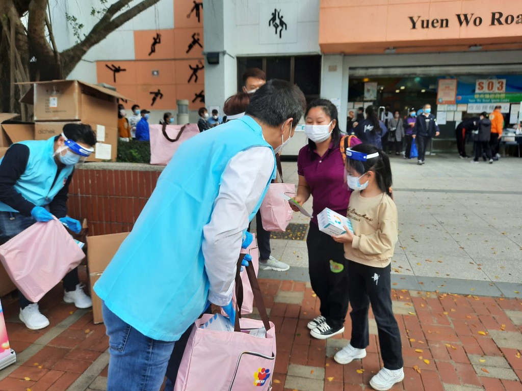 香港義工聯盟向每位接種疫苗的市民派贈內含5盒快測套裝的「抗疫愛心包」。