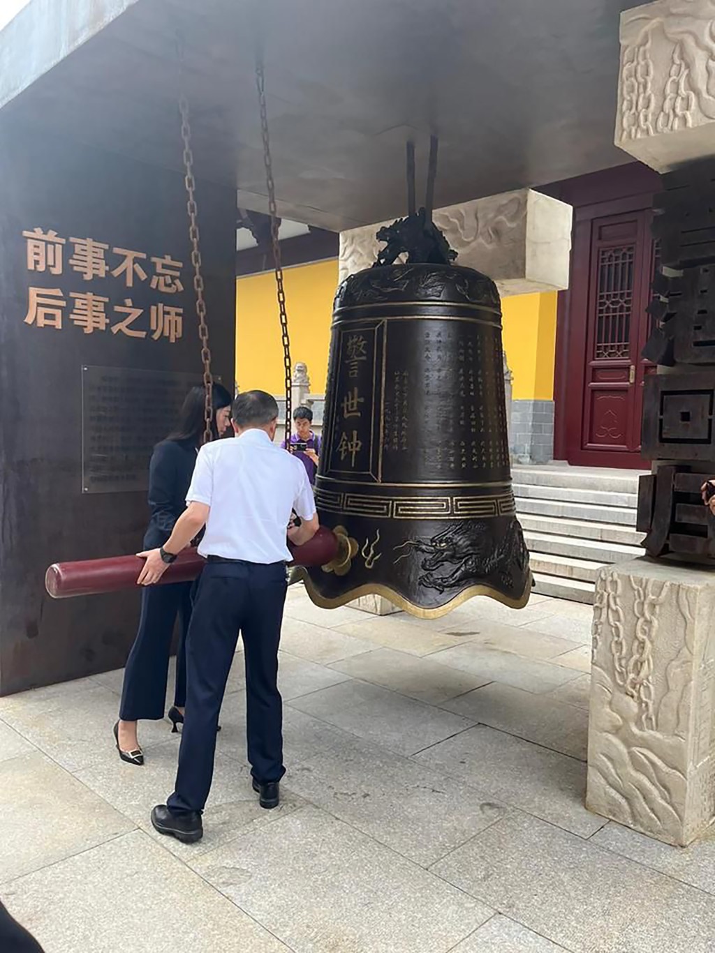 研習課程團長何明慧（左）參與寺內的青銅「警世鐘」撞鐘儀式。政府新聞處圖片