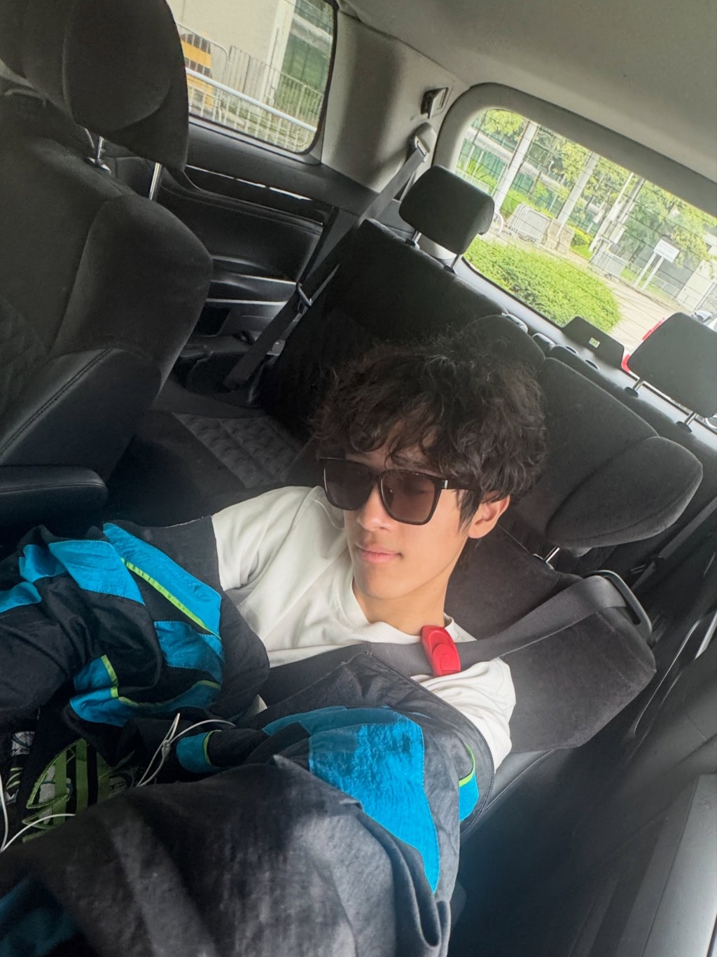 結束一天行程後，李立仁戴著墨鏡在車後座休息。