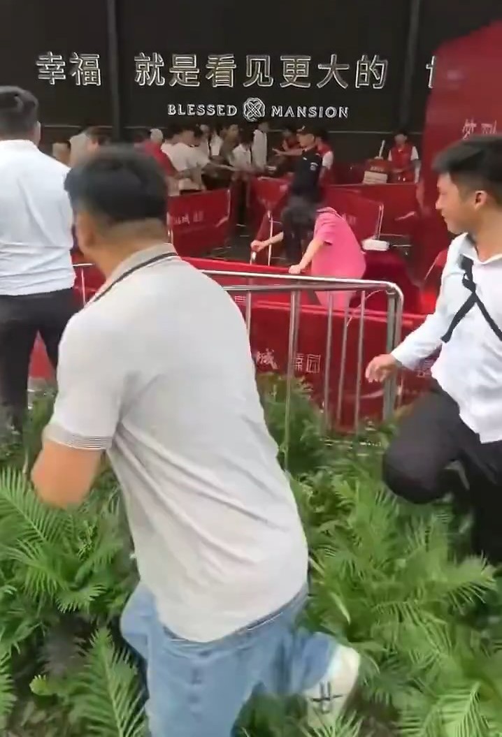 楼盘营销中心外,保安向人群喷辣椒水。微博@金融八卦女 楼盘营销中心外,保安向人群喷辣椒水。微博@金融八卦女
