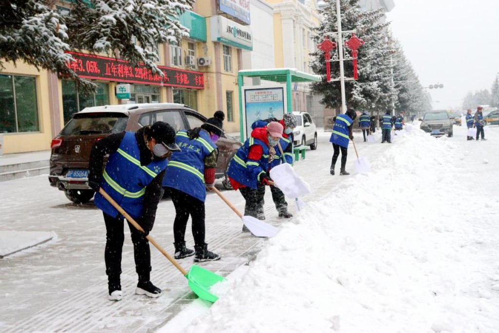 哈尔滨民众清理马路上积雪。