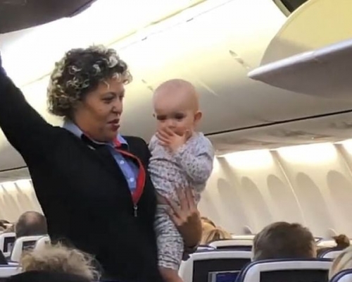該名女嬰亦甚為乖巧，不停向同機乘客送上飛吻。網圖