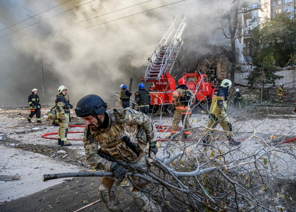 消防员帮助一名当地妇女从基辅被俄罗斯无人机袭击摧毁的住宅楼中撤离。AP