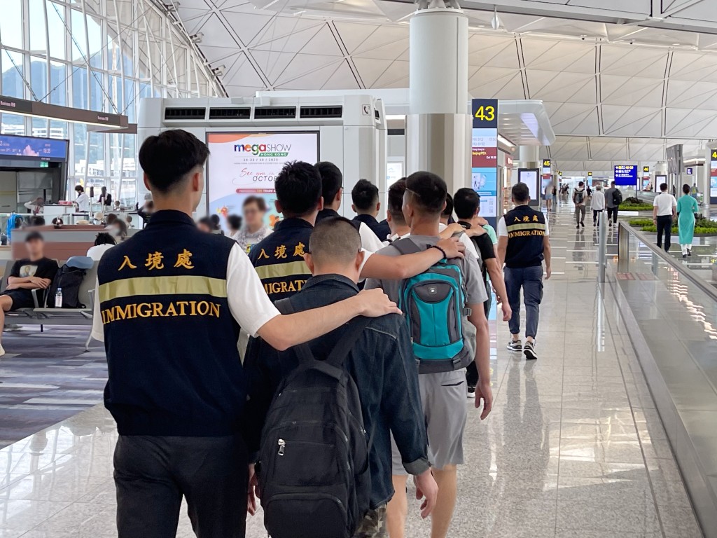 入境處人員押送被遣返者到機場登機。政府新聞處圖片
