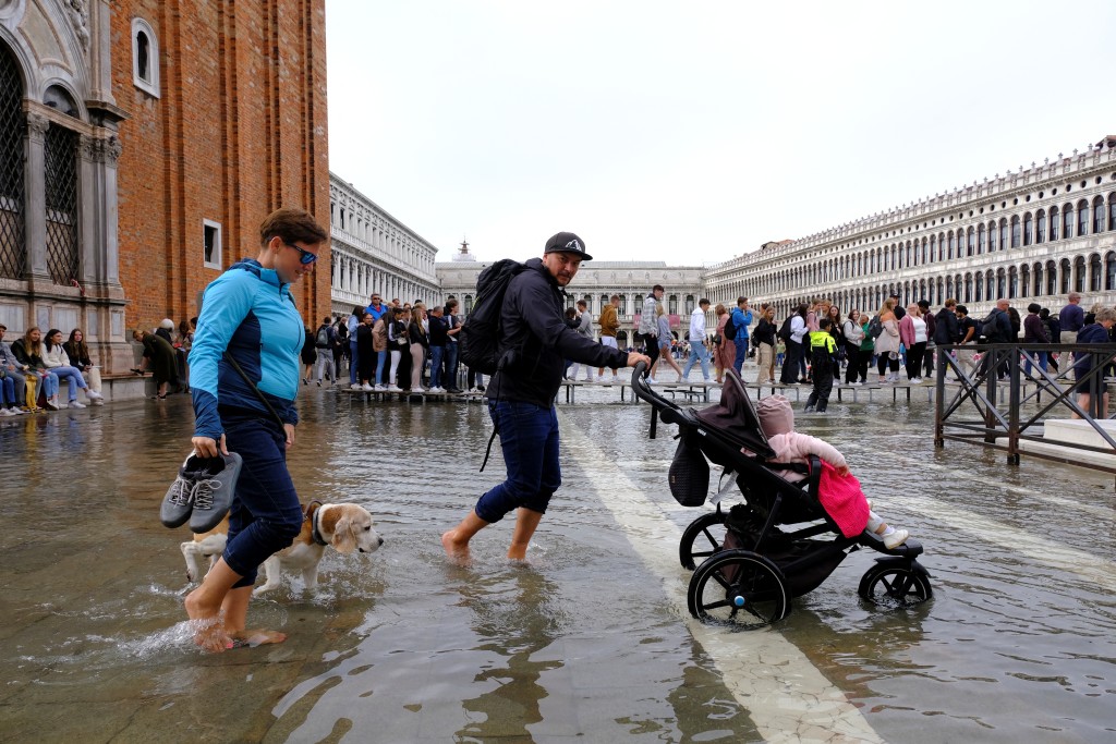 游客在威尼斯涉水而行。路透社资料图片