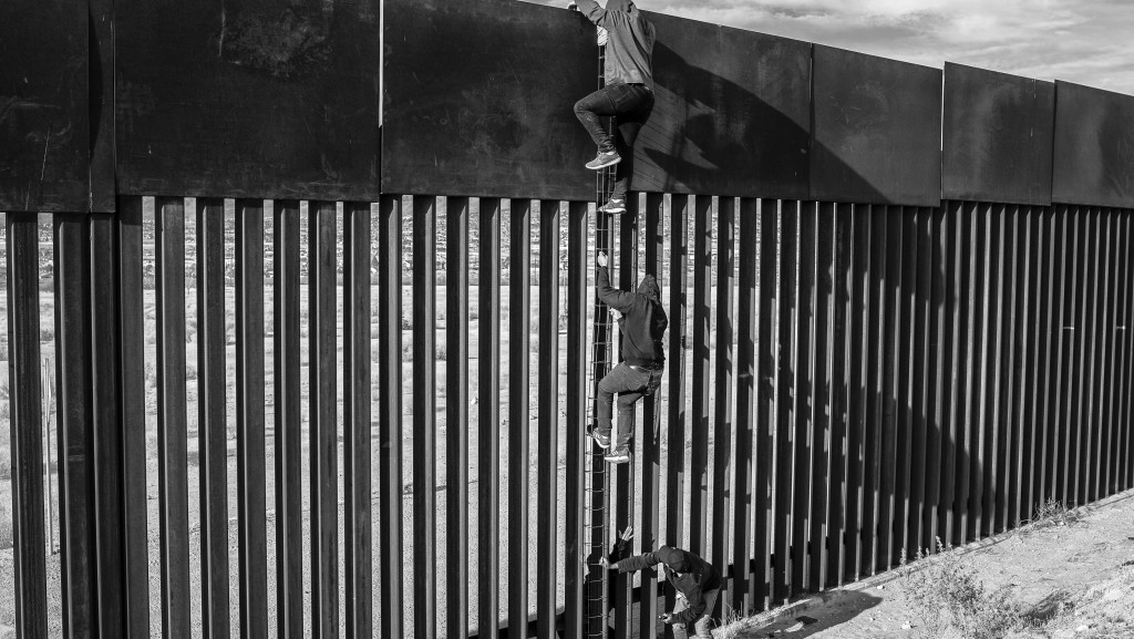 摄影师塞加拉(Alejandro Cegarra) 为《新时代》/彭博社拍摄，题为《两堵墙》的系列作品，赢得世界新闻摄影奖长期计画奖。图为系列其中一幅图片，显示移民用自制梯子爬墙的情景。 美联社
