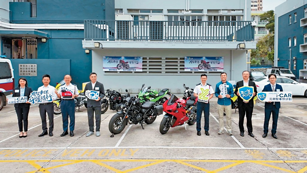 元朗警區指揮官梁仲文總警司（右四）、刑事調查總督察冼珈瑤（左一）、元朗區撲滅罪行委員會主席陳建業（左四）等人介紹「智車保計劃」，將向區內電單車車主免費派發兼顧防範與追蹤功能的「智車保險包」。