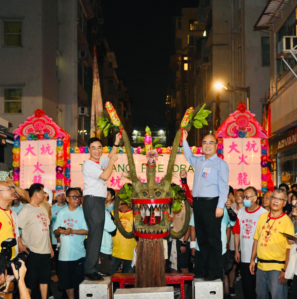 马会主席利子厚（前排左）及中联办港岛工作部部长薛惠君（前排右）为大坑火龙簪龙花。