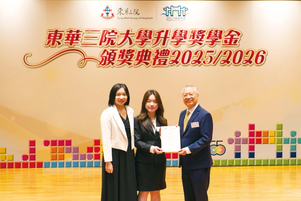 獎學金捐設人李沅鈞先生（右）頒發「東華三院李文輝先生夫人大學獎學金」予得獎生林佳霖同學，與東華三院甲寅年總理中學邱春燕校長（左）合照。