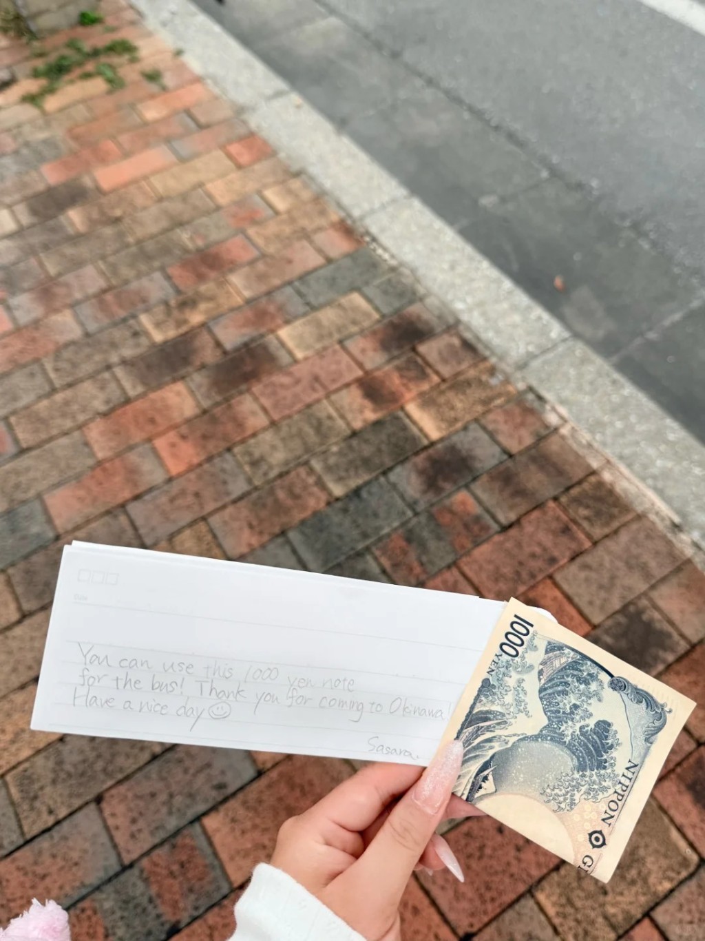 小女孩下車前將紙條和1000日圓紙幣塞給「魚魚」。小紅書@魚魚