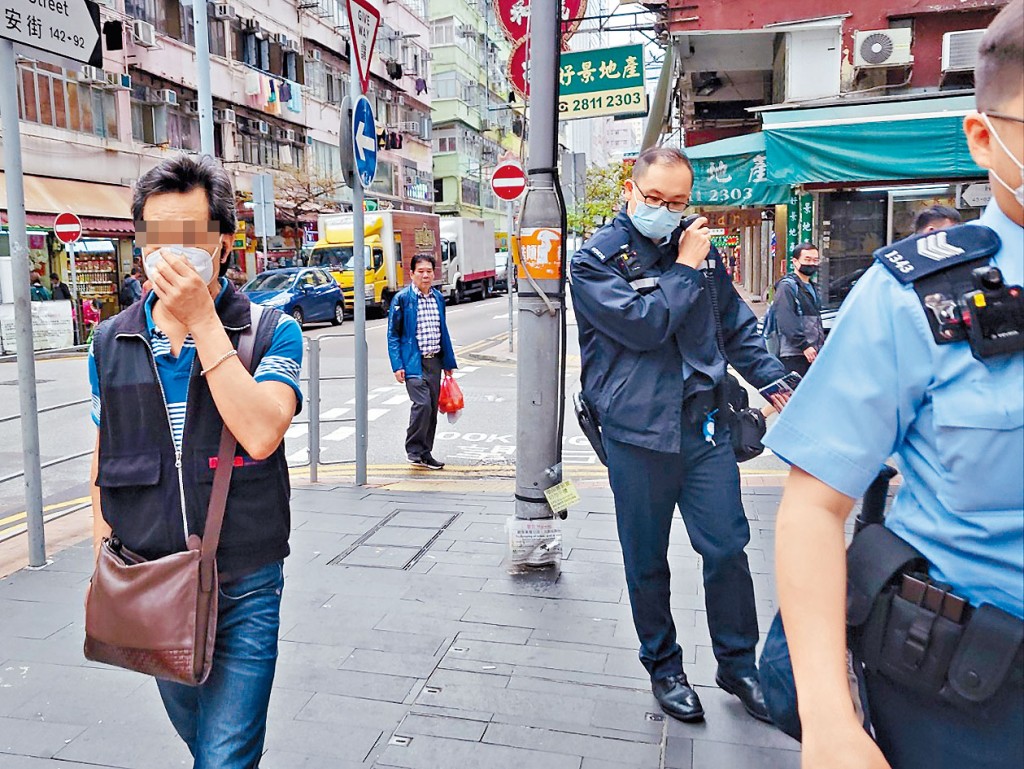 警員帶同男事主(左)在附近一帶兜截女賊。