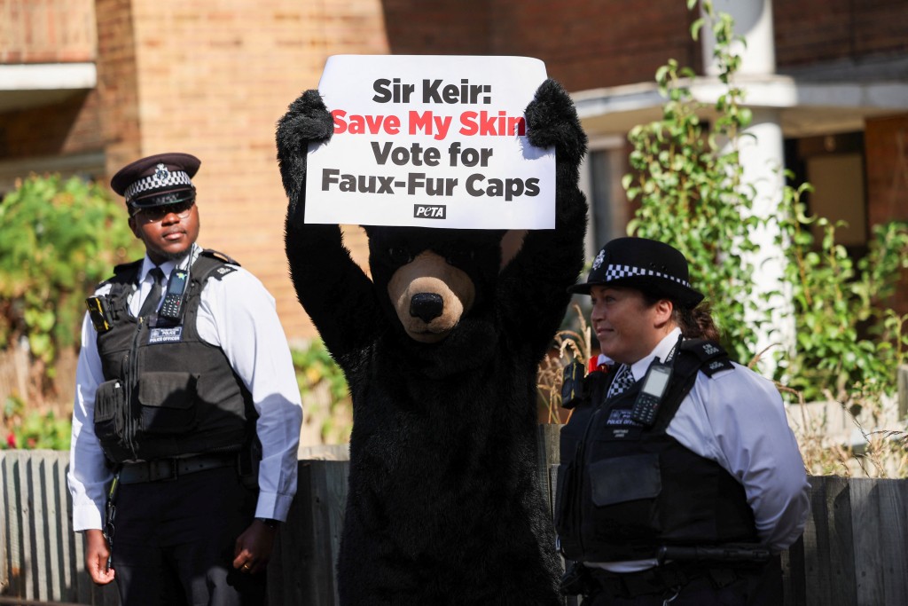 投票所外一名打扮成熊的爱护动物组织 (PETA) 活动人士举著牌子。 路透社