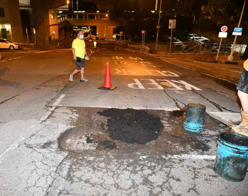 事後修路工人用瀝青將路陷鋪平。丁志雄攝
