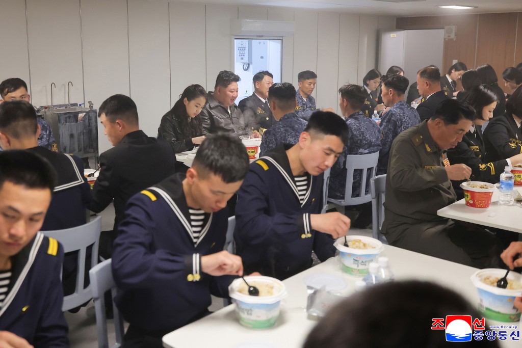 金正恩偕女兒金主愛（後排中）與驅逐艦上官兵一同用膳。美聯社