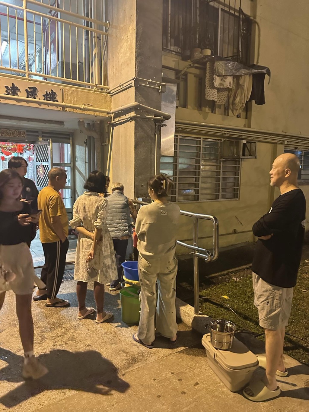 有居民持膠盤，落樓下花槽旁的水喉取水。Threads：simpsonlalala