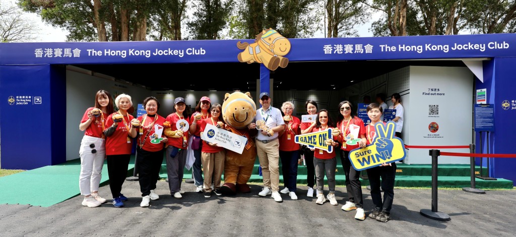 马会义工队CARE@hkjc成员在观众村制作气球公仔，并与马会公司事务执行总监谭志源（右六）合照。