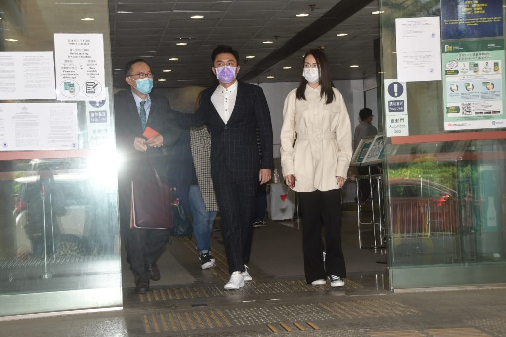 楊明下午在女友莊思明（右）、代表律師清洪（左）陪同下步出法院。