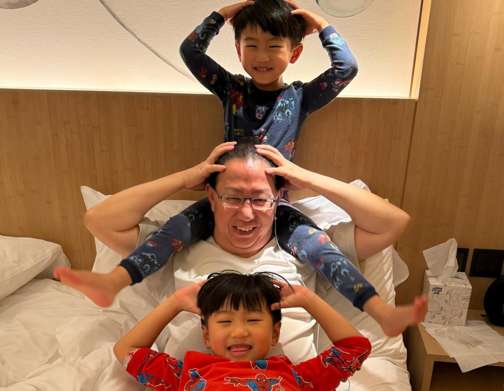 爷爷刘家豪与两个孙仔玩叠罗汉。