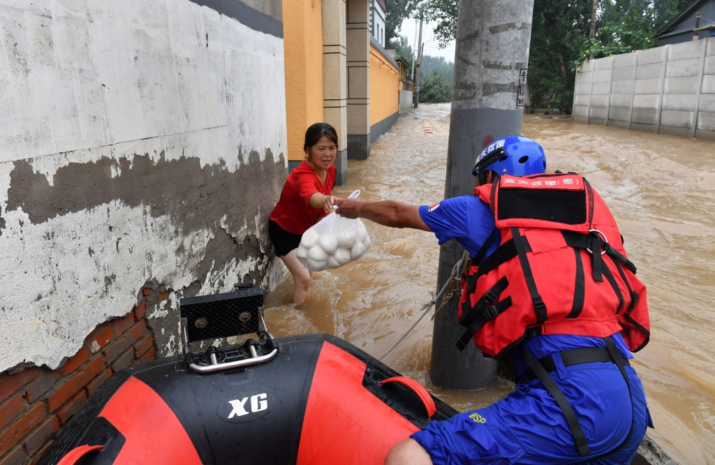 救援人員在涿州向災民提供食物。 中新社