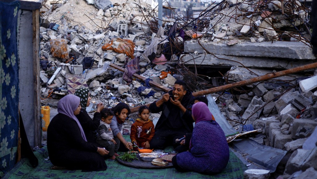 斋戒月期间，一个家庭在废墟中用餐。 路透社