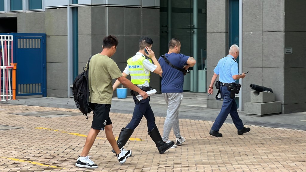 蓝衫（图右二）者相信为涉事客货车司机，他到新界南总区总部自首。