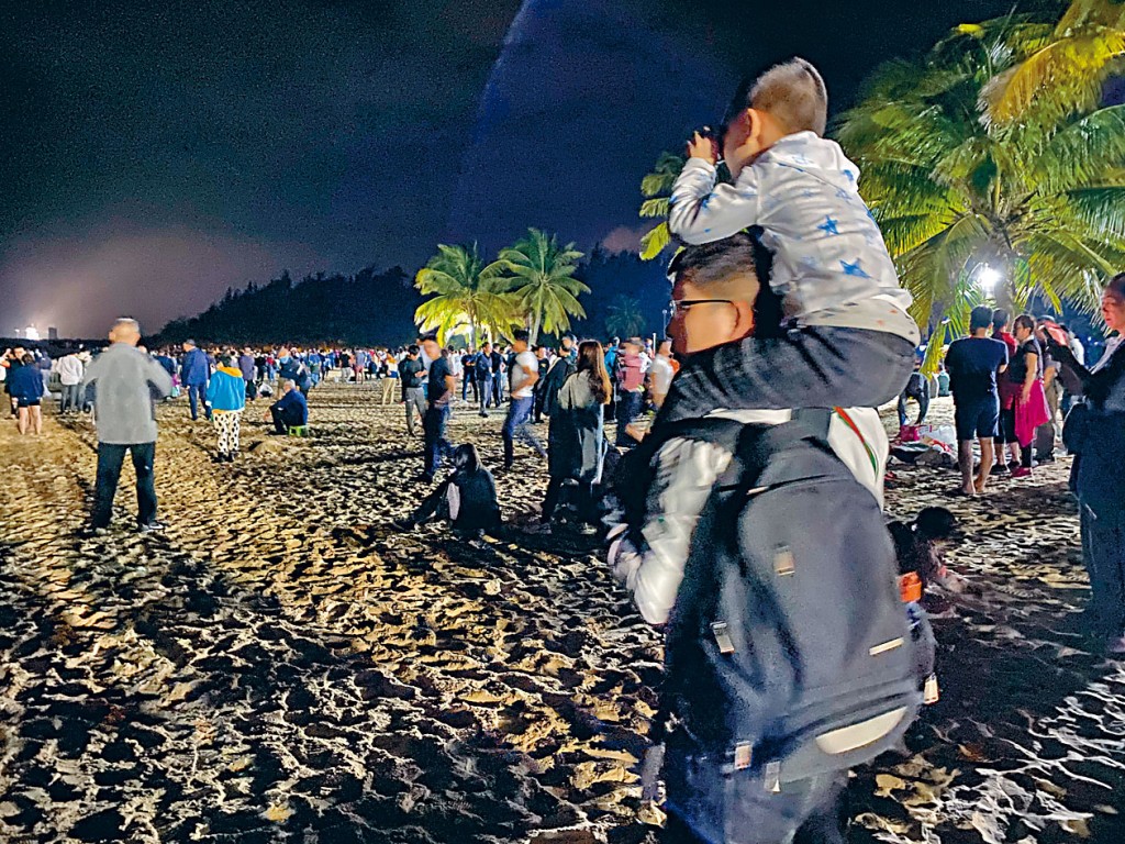 民众在西昌用望远镜见证历史一刻。