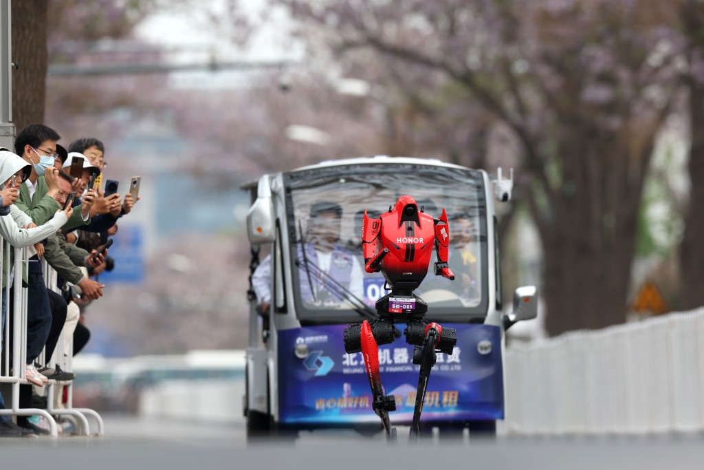 遊人夾道為參賽機械人打機。中新網