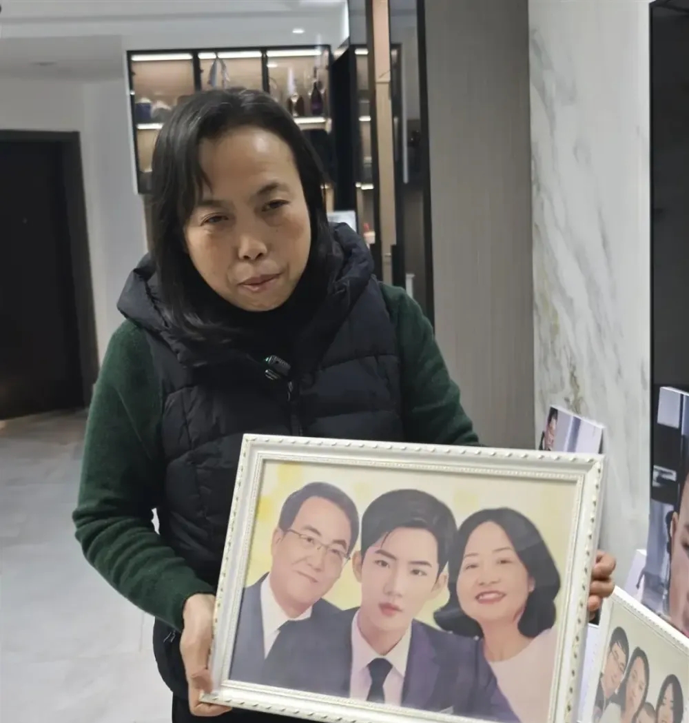 死者家屬胡娟抱著網友畫的一家三口的「未來」畫像。 死者家屬胡娟抱著網友畫的一家三口的「未來」畫像。