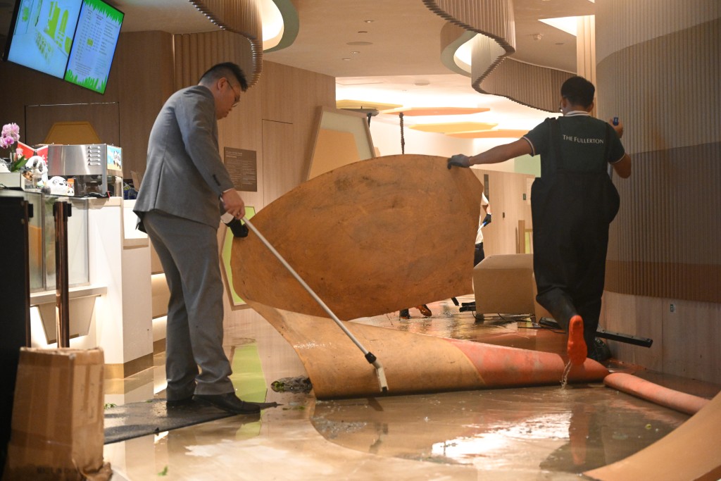 富麗敦海洋公園酒店玻璃門爆裂，工作人員清理現場。