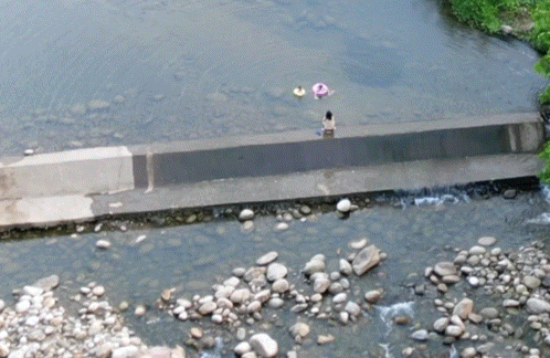 一公里下的堤坝处三母子在玩水。