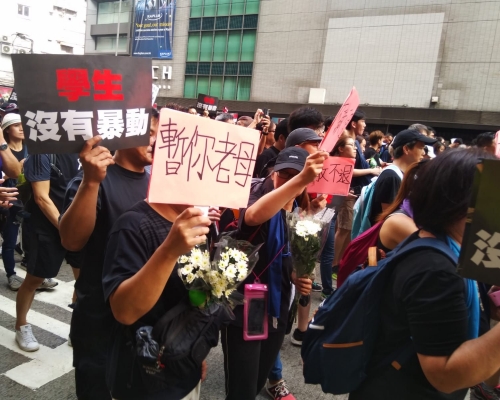 不少人亦手持鮮花、紙花或繫上白絲帶
