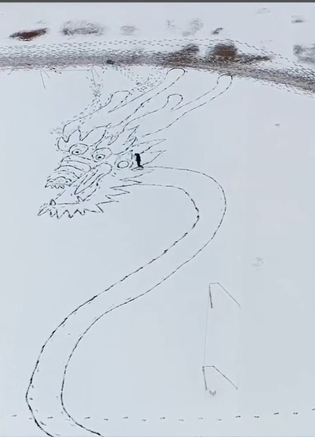 赵先生用了2小时在雪地脚画出百米长巨龙。影片截图
