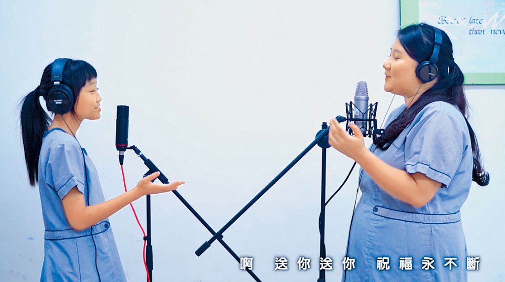 兩名女生走進白色背景的錄音室,「一鏡到底」在麥克風前完成表演。