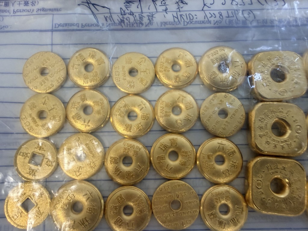 警方早前檢獲的一批證物，包括大批金粒及現金。資料圖片