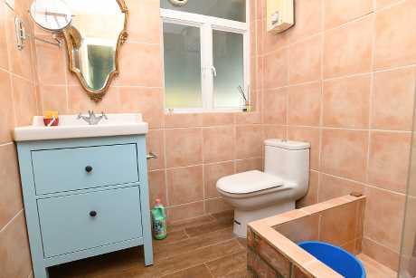 圖中浴室用橙色牆身，配上藍色收納櫃，極富特色。