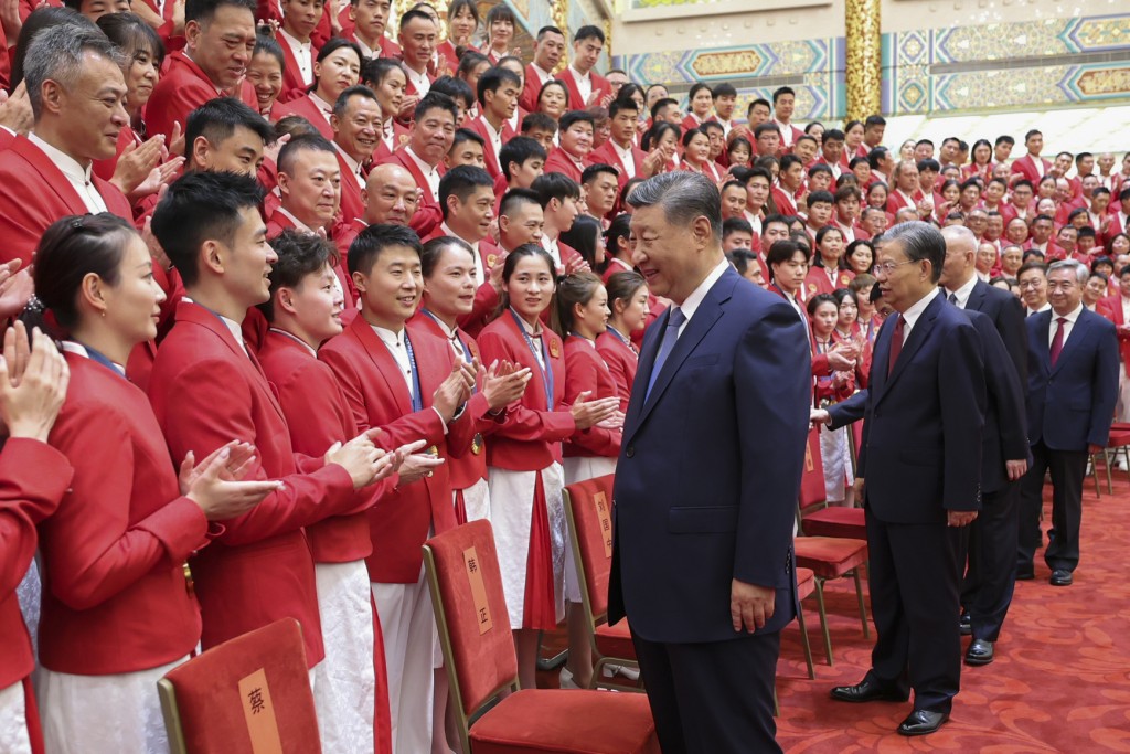 习近平停步与运动员谈笑风生。(新华社)