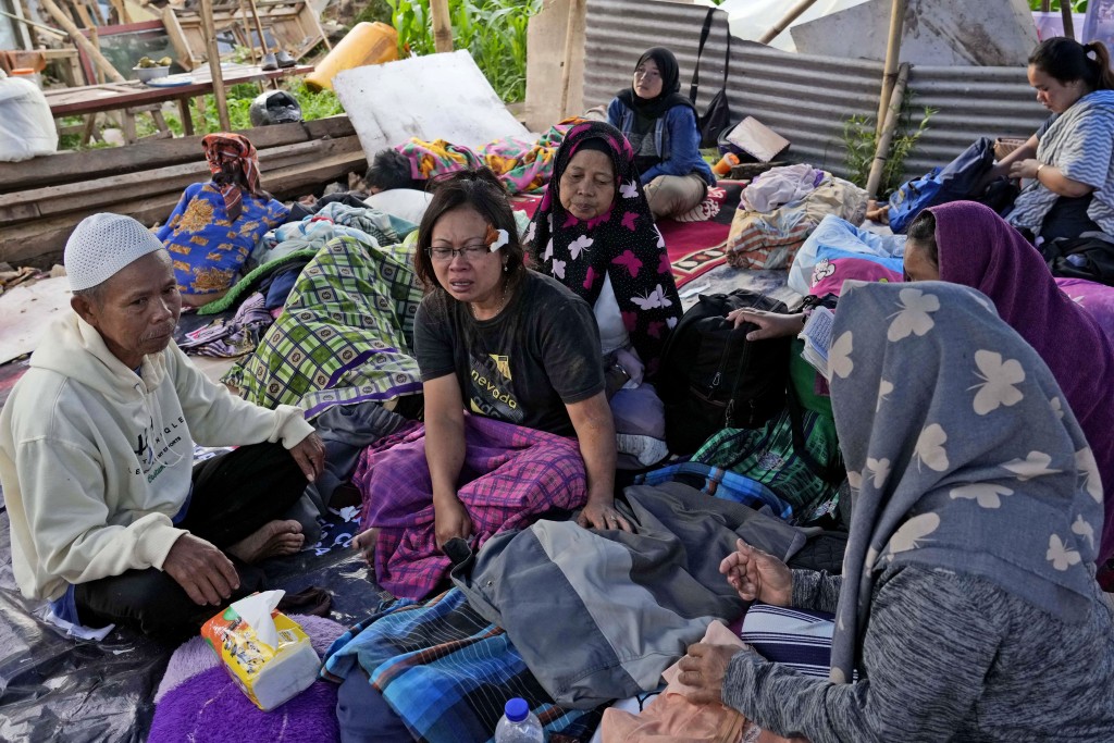 印尼西爪哇地震中喪生的兒子的婦女在屍體旁哭泣。AP