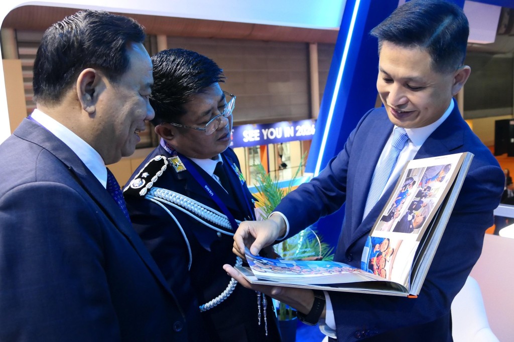 消防處處長楊恩健（右）向緬甸消防局局長Myat Thu（中）展示消防處參與緬甸地震救援的相冊。香港消防處fb圖片